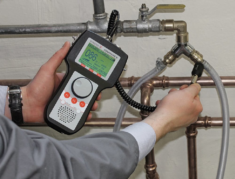 Plumber testing pipes with electronic leak detection equipment in Albany